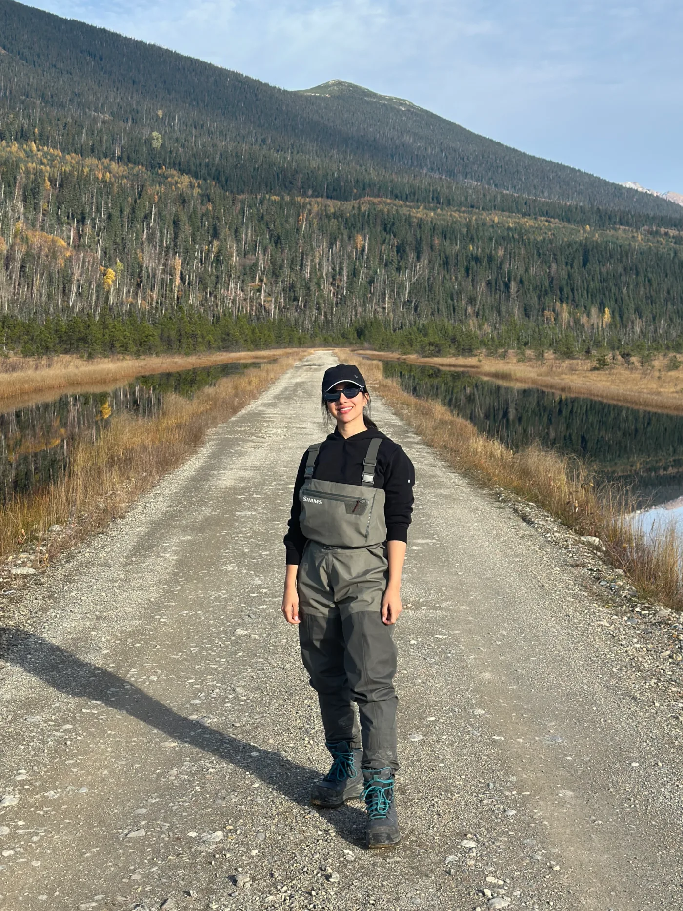 A personal photograph on a gravel road between forested hills.
